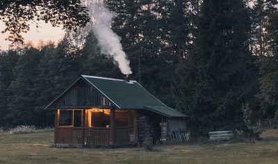 与烟的烟囱小屋附近的树木
